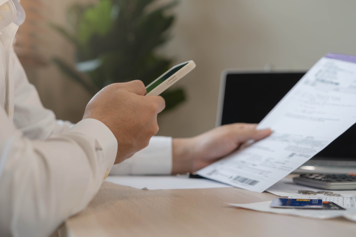 Member holding a phone with a paper document